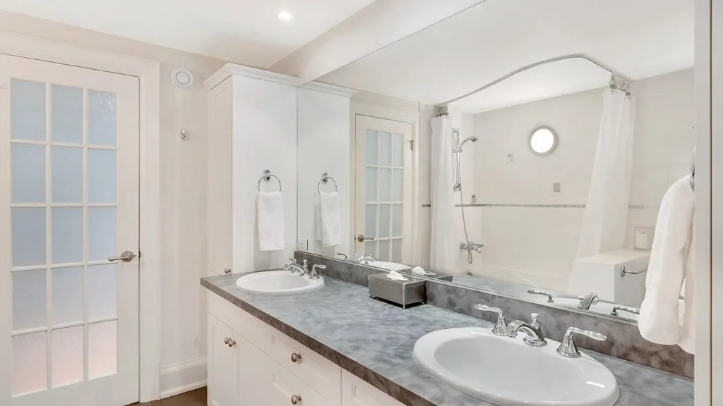 A bright bathroom with a double sink cabinet